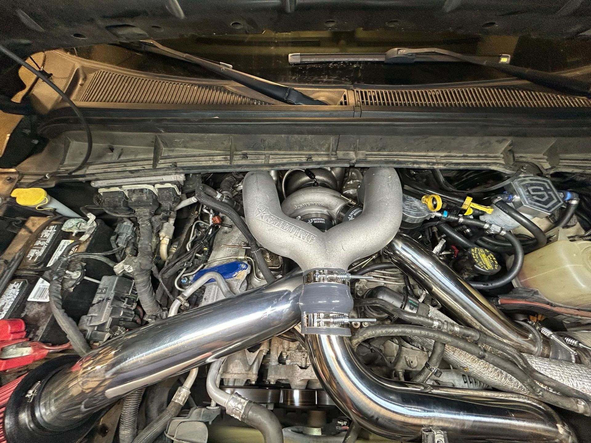 A close up of a car engine with the hood up.