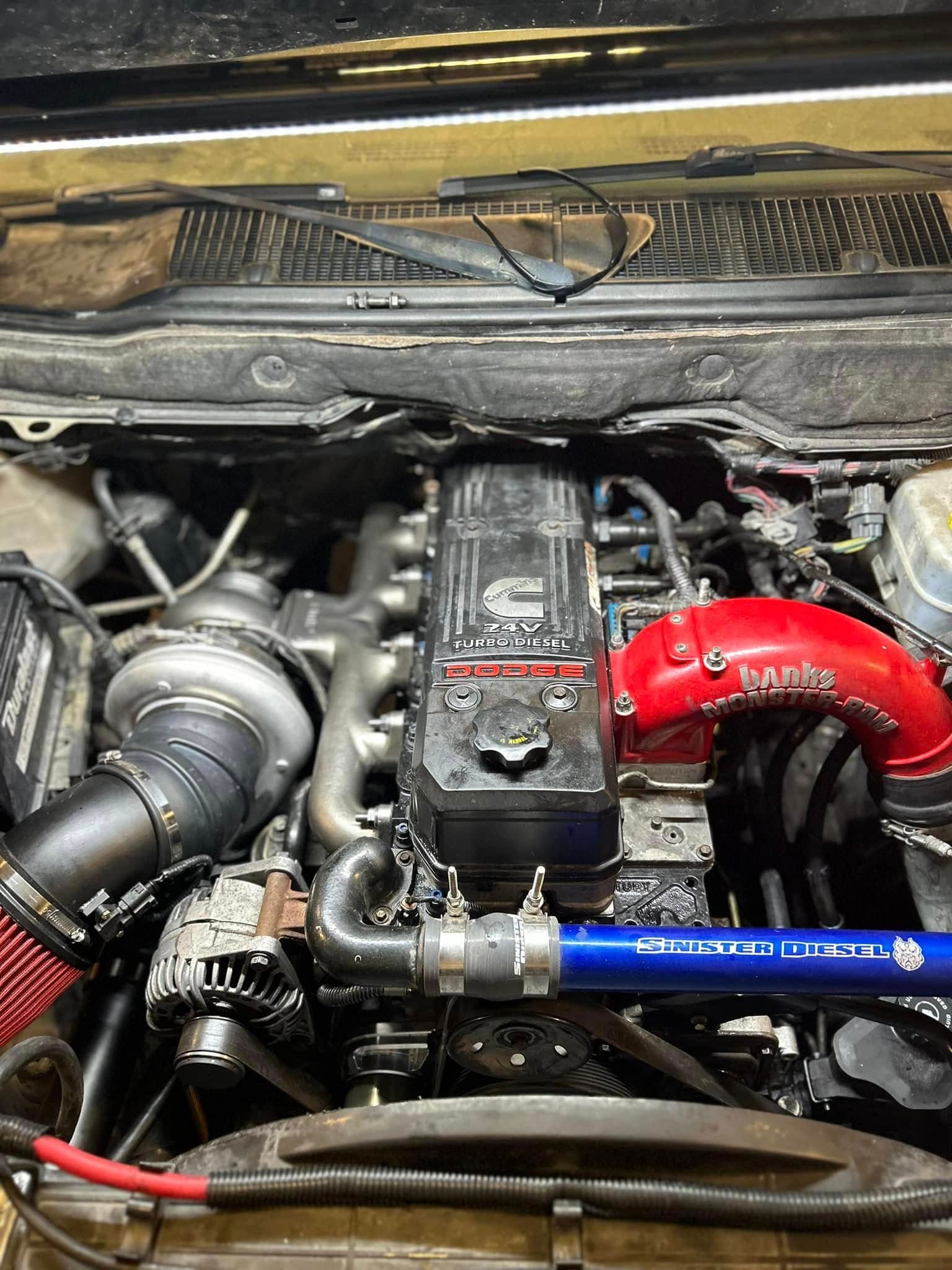 A close up of a car engine with the hood open.