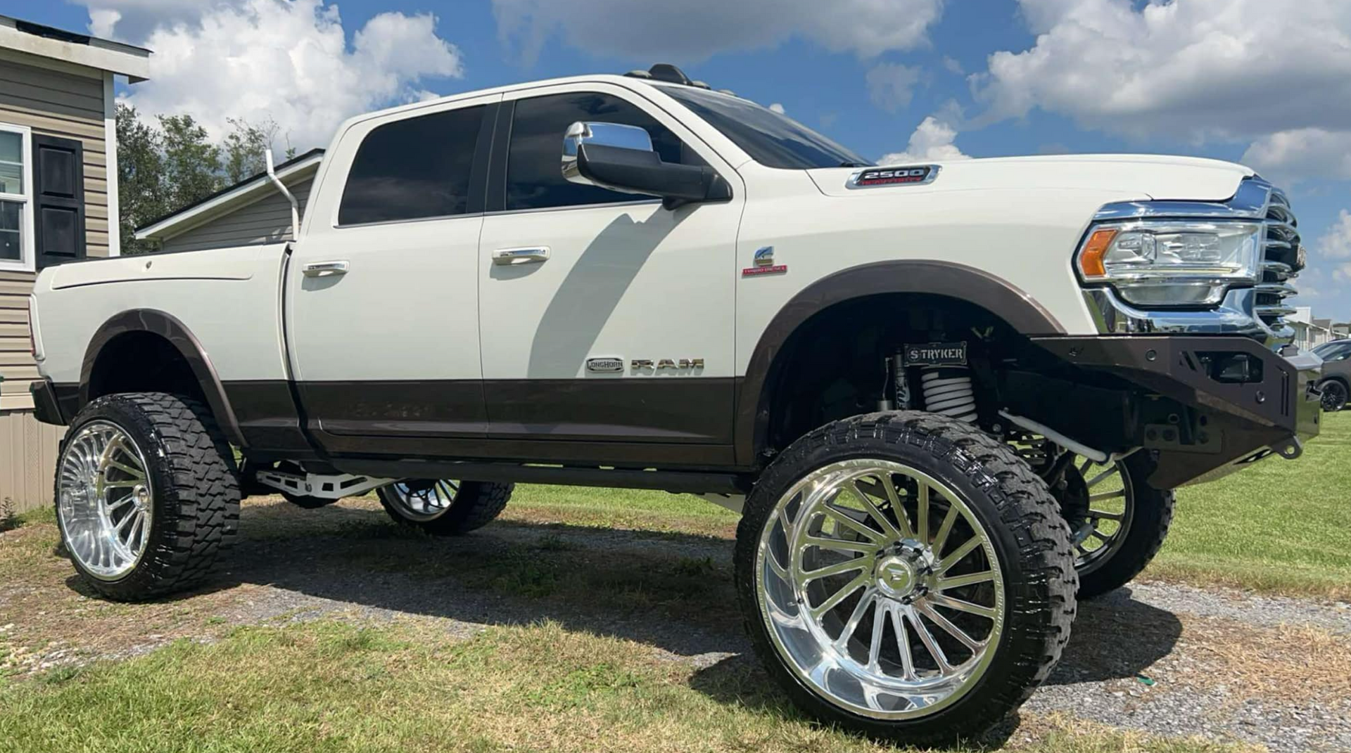 A white dodge ram truck is parked in front of a house.