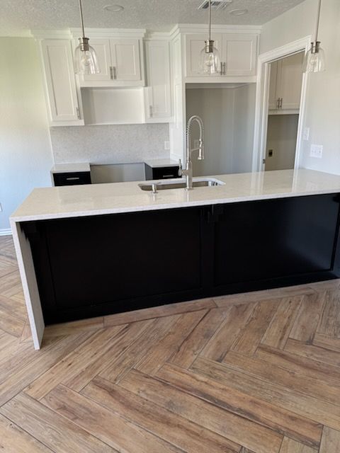 A kitchen with a large island and a sink.