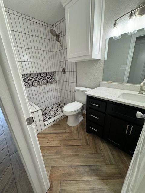 A bathroom with a toilet , sink and shower.