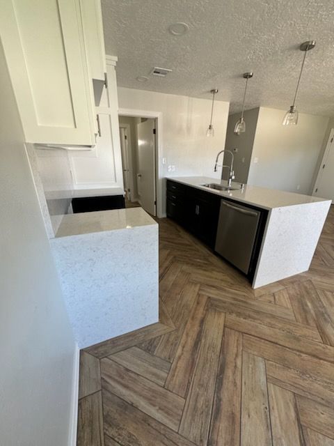 A kitchen with a large island and a stainless steel dishwasher.