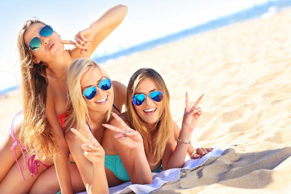 group of girls in bikini lying down on a beach