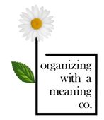 Logo with white daisy, green leaf, and text &ldquo;organizing with a meaning co.&rdquo;