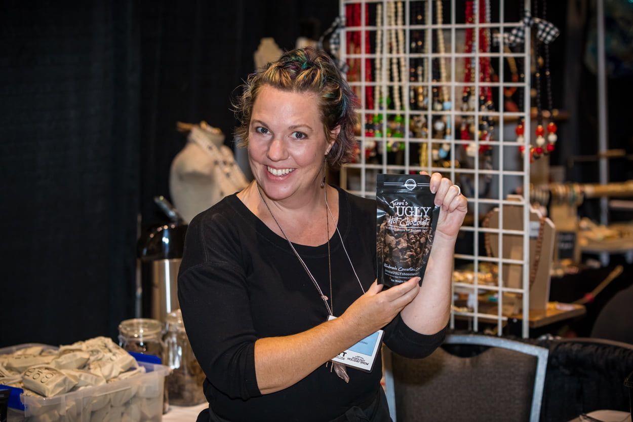 A woman in a black shirt is holding a cup in her hands.