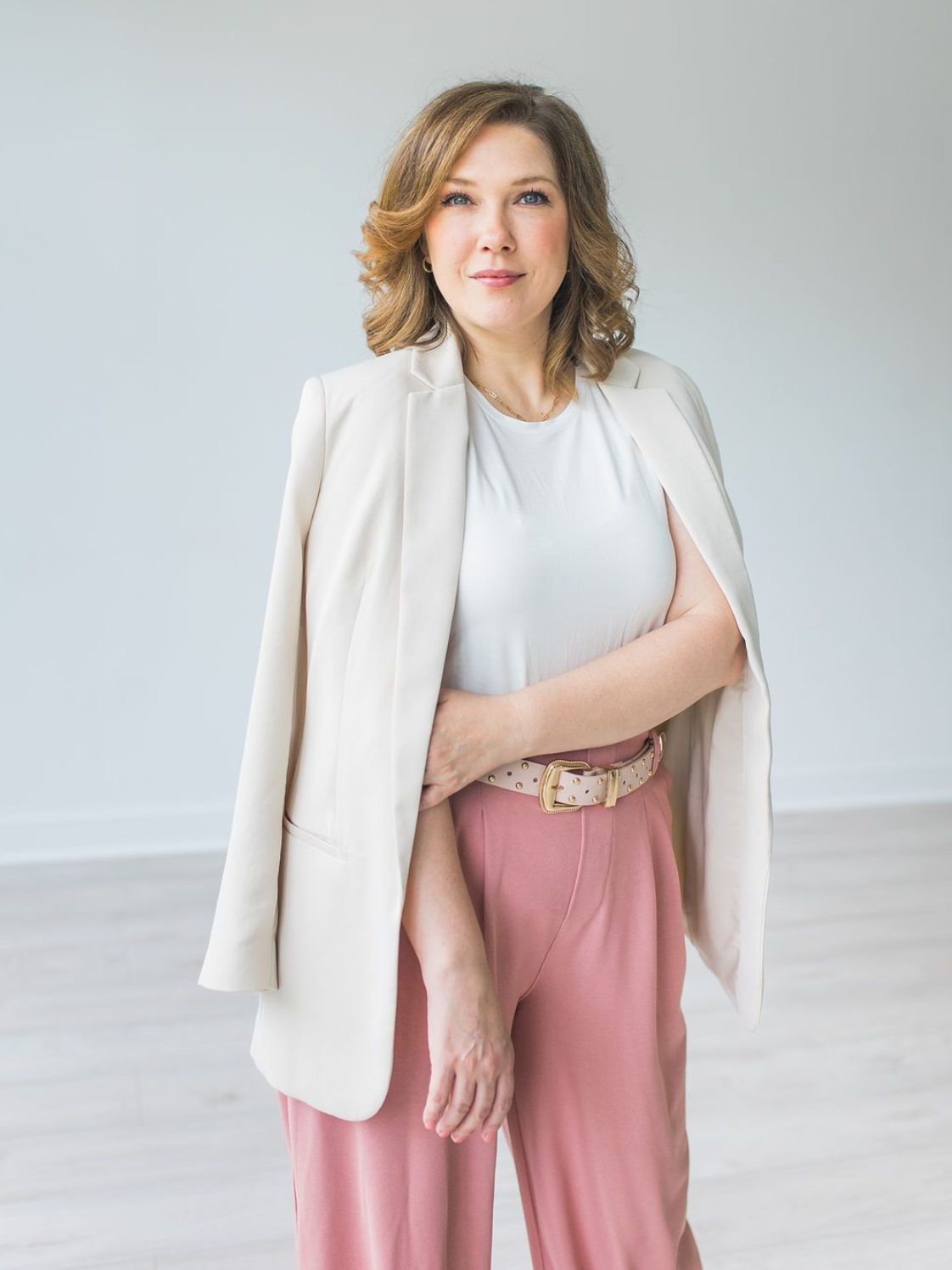 A woman is sitting on a couch holding a cup of coffee.