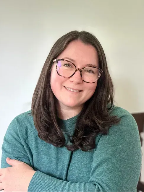 A woman and man standing in front of bookshelves with records