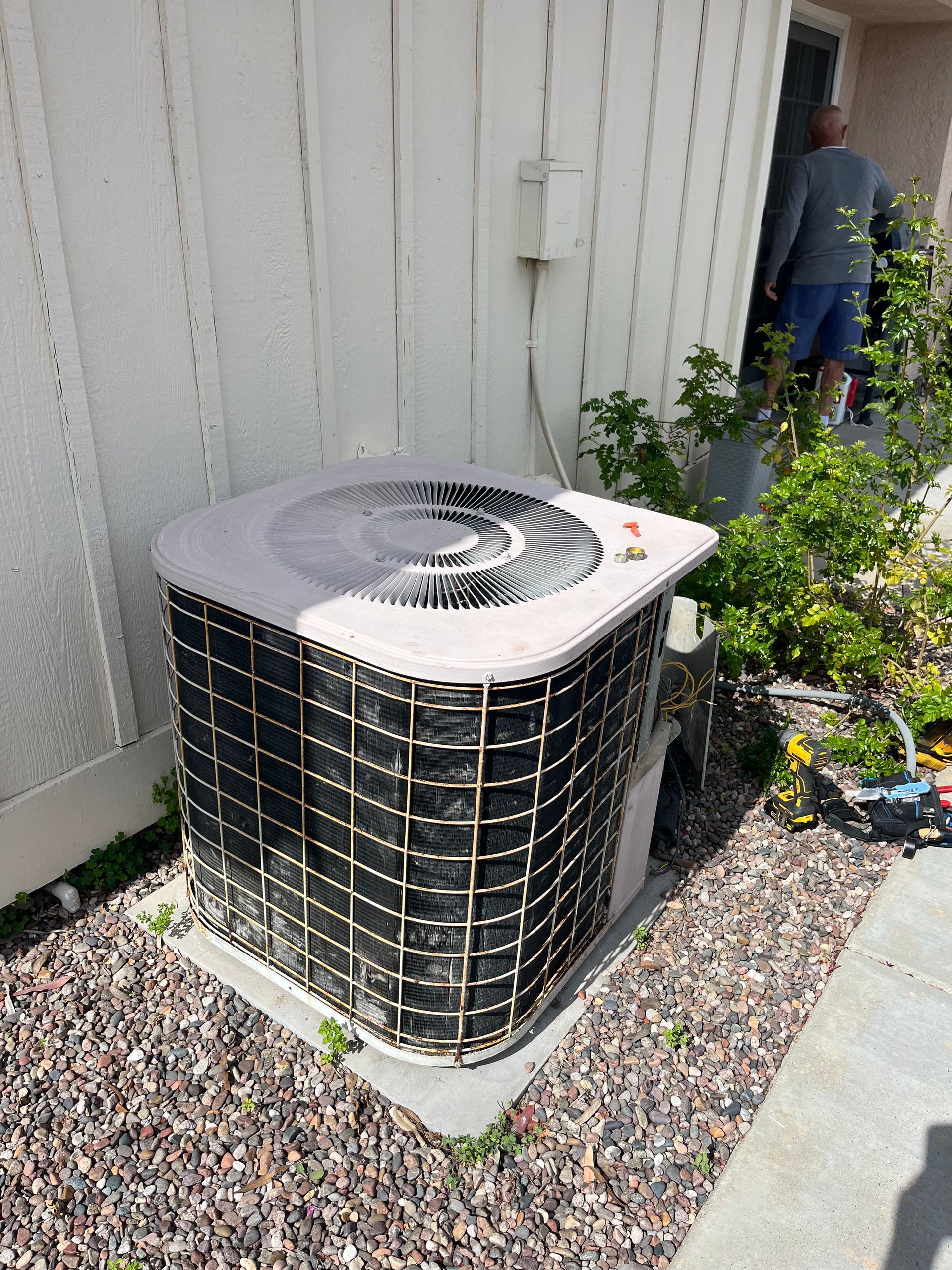 AC unit outside a house, next to a person.