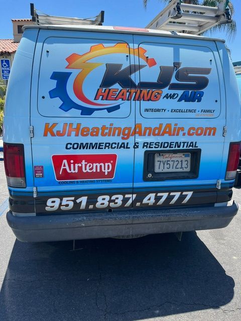 Back of a blue and white van with HVAC company logo and contact info.