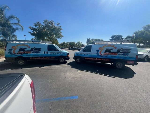 Two service vans in a parking lot with the logo 