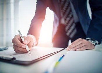 Man Signing a Contract — Spokane, WA — Loan Fox Inc.
