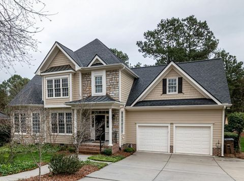 A large house with a gray roof and white garage doors