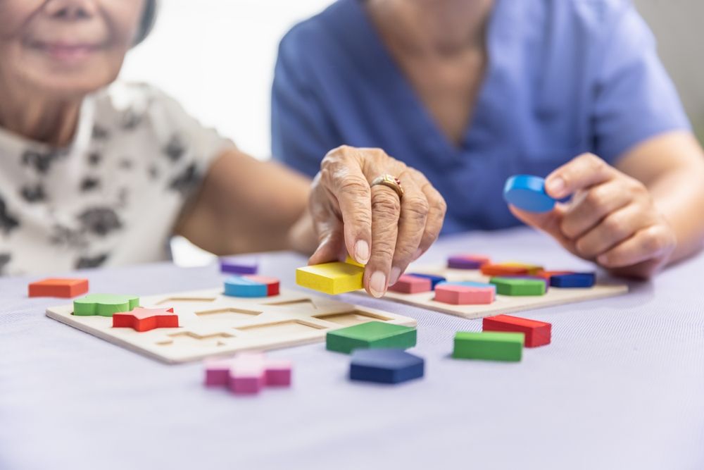 two women are playing a game with wooden blocks