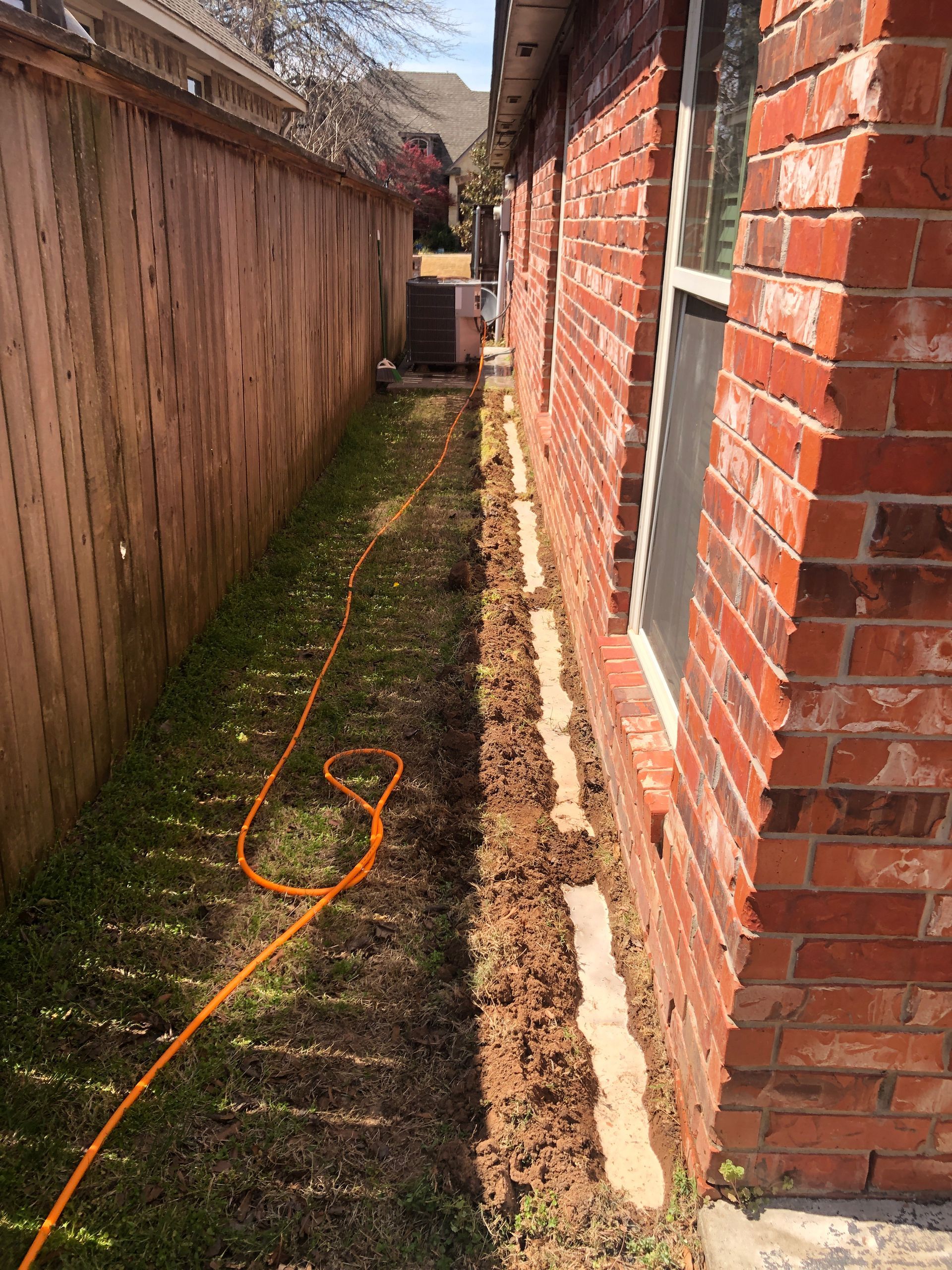 Person in protective suit spraying inside a kitchen cabinet.