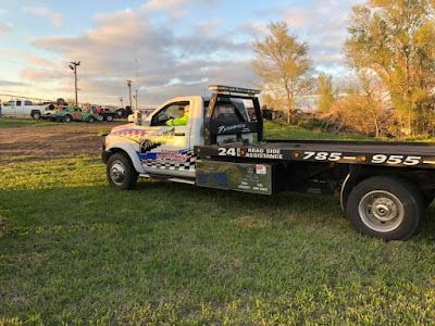 A tow truck is parked in a grassy field.