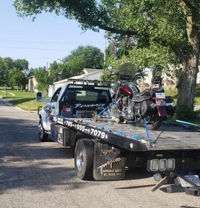 A tow truck with a motorcycle on the back of it
