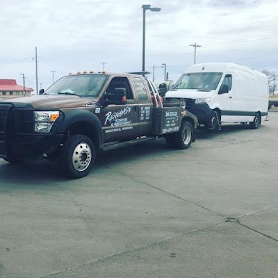 Two tow trucks are parked next to each other in a parking lot.