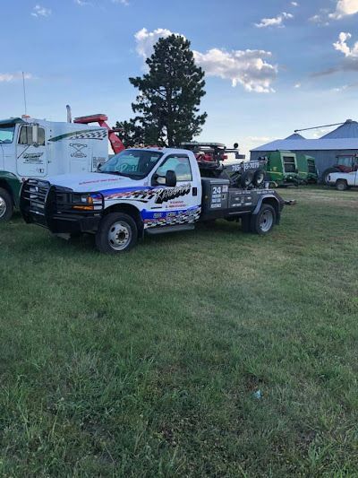 A tow truck is parked in a grassy field.