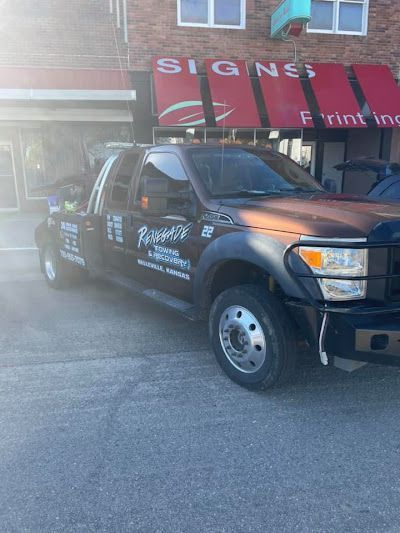 A truck is parked in front of a building that says signs