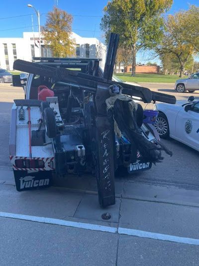 A tow truck is carrying a large object on the back of it.