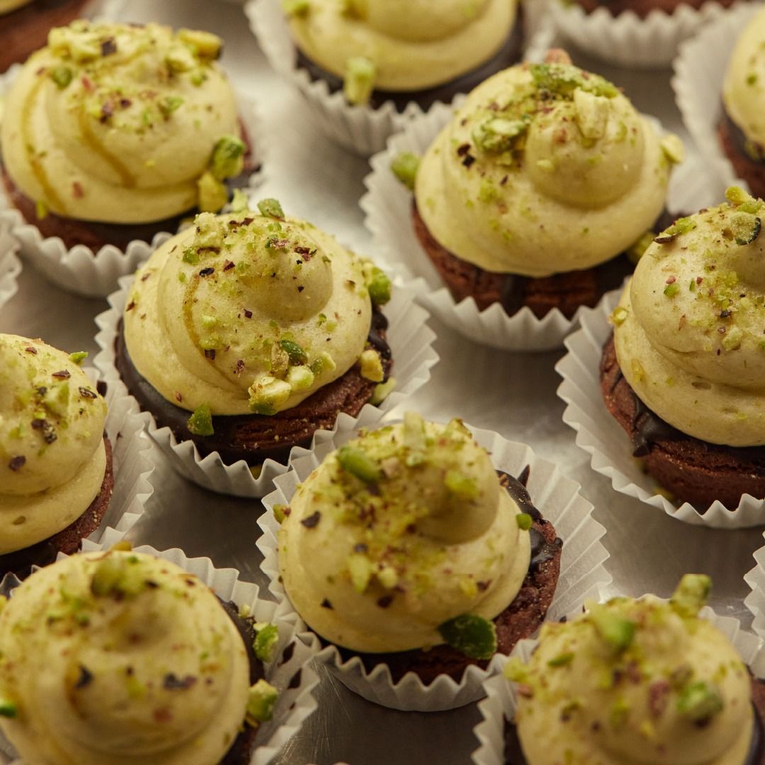 Un mucchio di cupcakes con glassa e pistacchi sopra