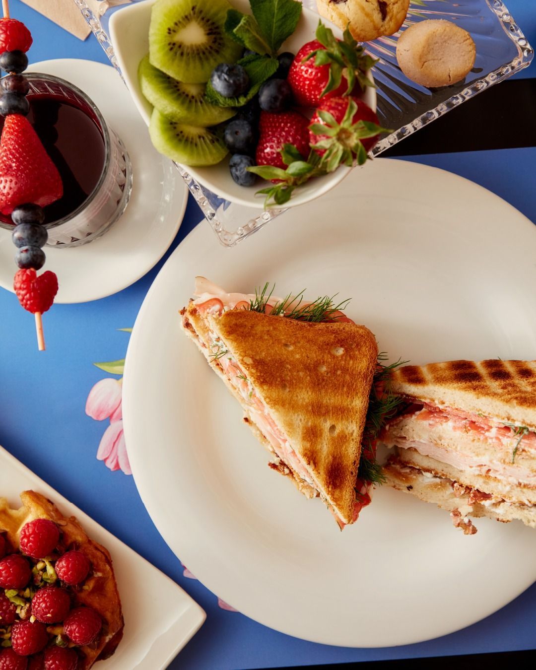 Un gruppo di persone è seduto a un tavolo in un ristorante e mangia e beve vino.