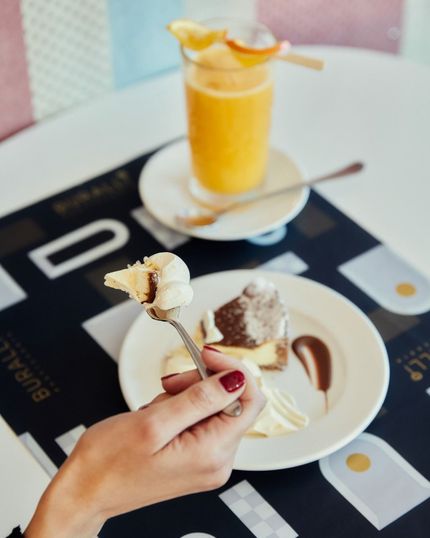 Una persona tiene una forchetta sopra un piatto di cibo