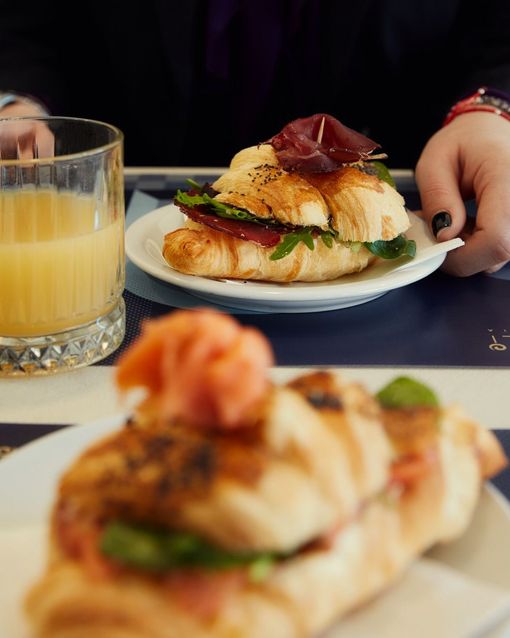 Un primo piano di un piatto di cibo con un bicchiere di succo d'arancia sullo sfondo