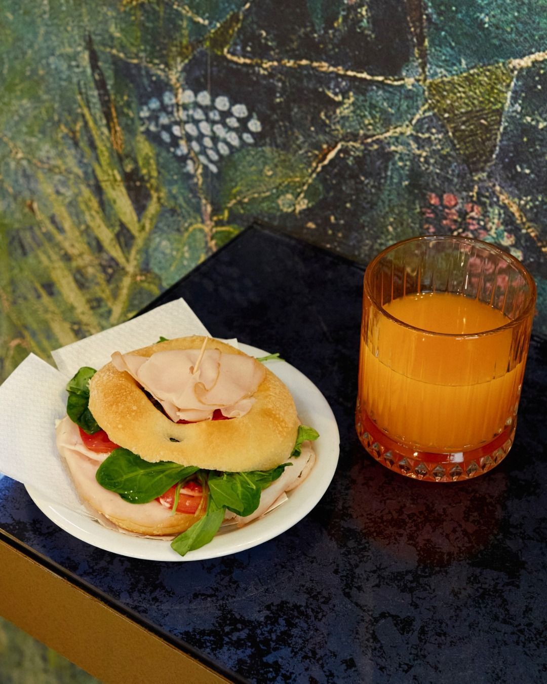 Un piatto di cibo accanto a un bicchiere di succo d'arancia