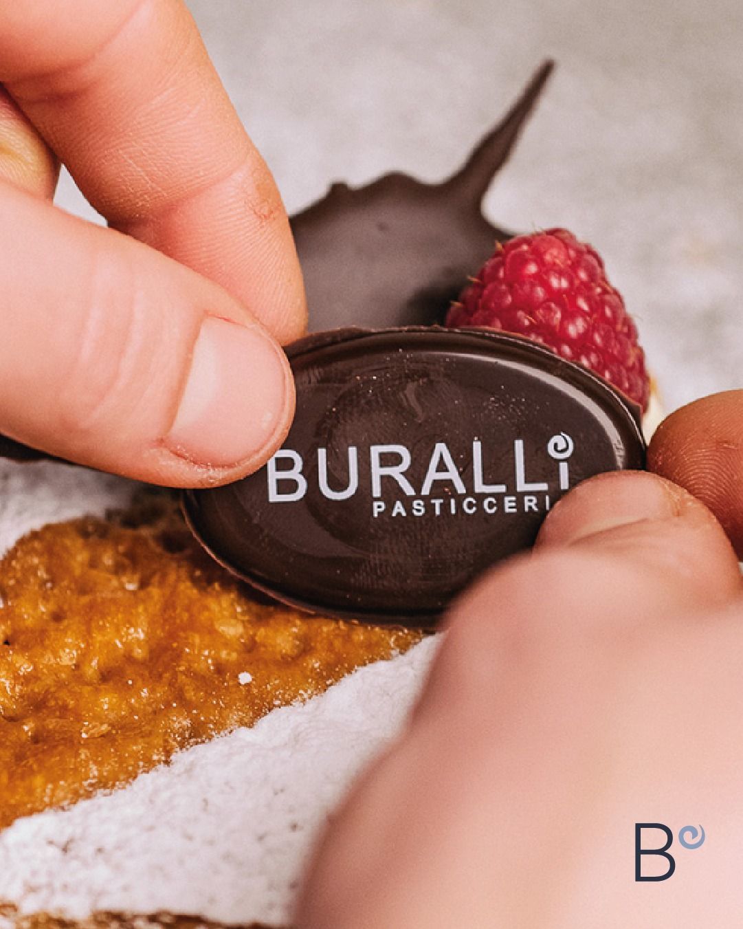 Una persona sta mettendo un'etichetta su una fetta di torta che dice buralli pasticceria