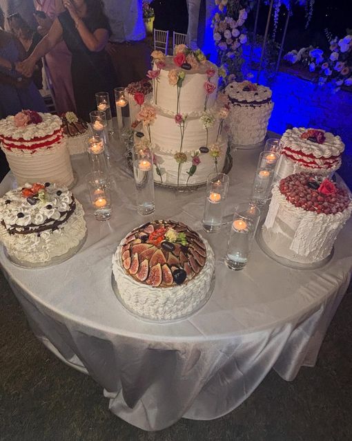 Un tavolo con tante torte e candeline sopra