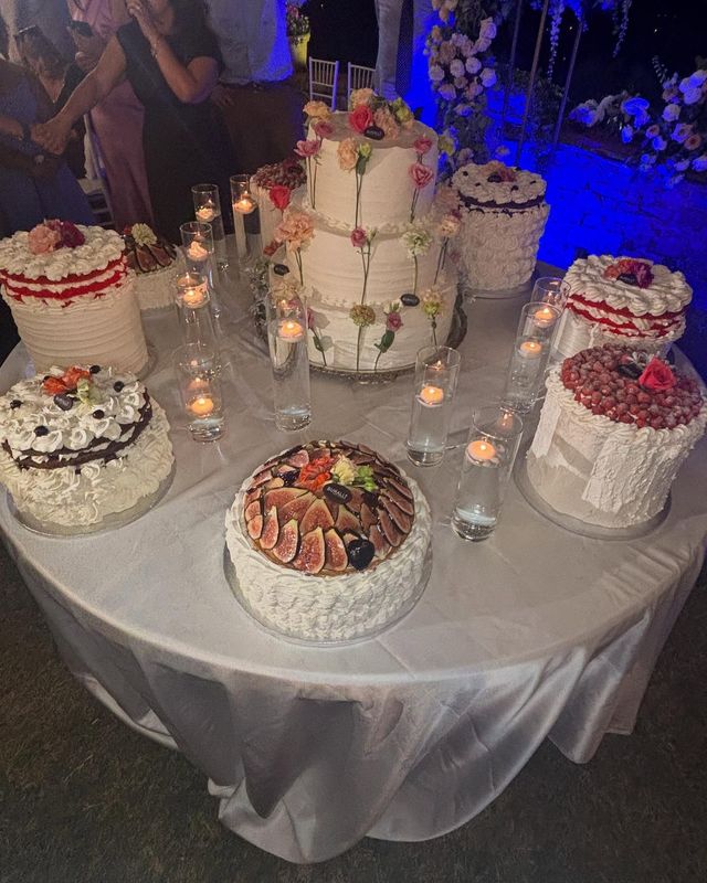 Un tavolo con tante torte e candeline sopra