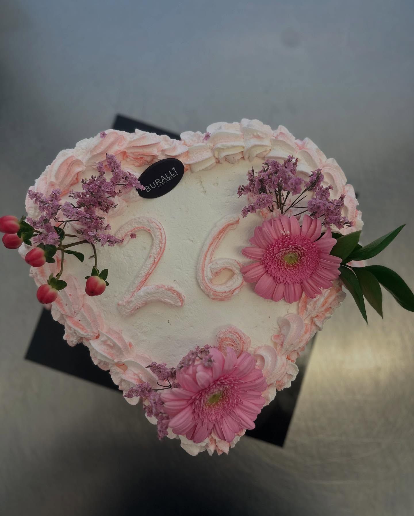Una torta a forma di cuore con il numero 26 sopra