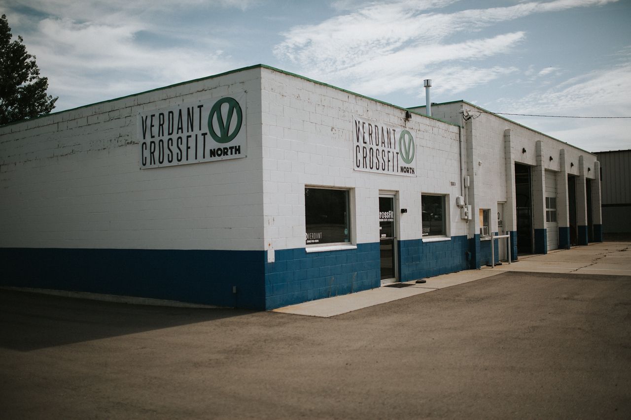 Verdant CrossFit North fitness facility in Star, ID with white walls, blue trim, and logo against a cloudy sky.