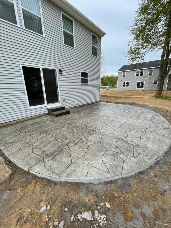 A concrete patio is being built in front of a house.