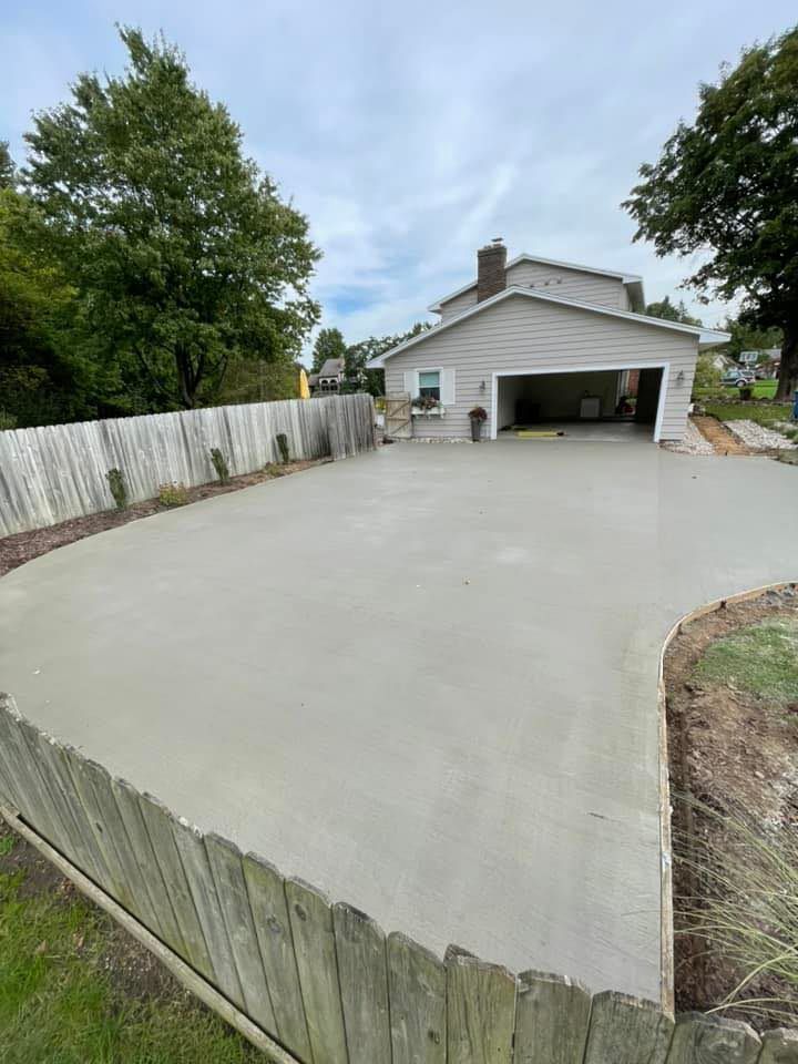 A concrete driveway is being built in front of a house.