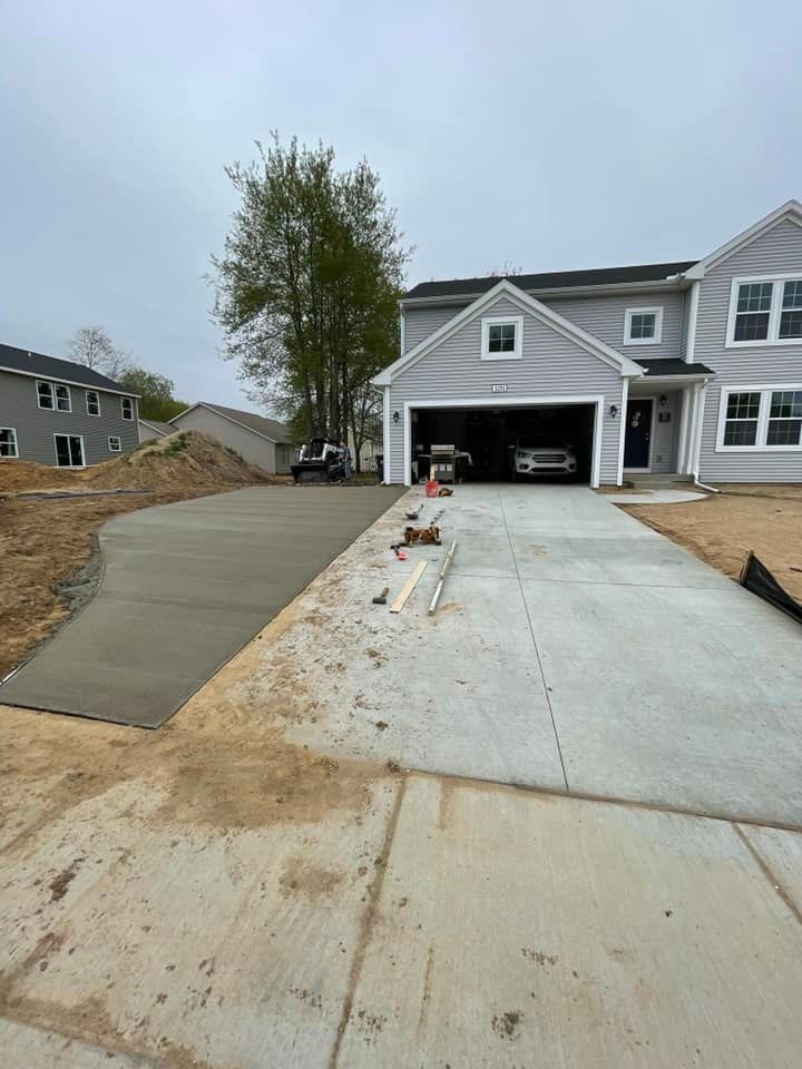 A concrete driveway is being built in front of a house.