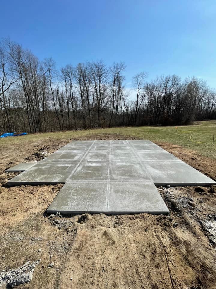 A large concrete slab is sitting in the middle of a dirt field.