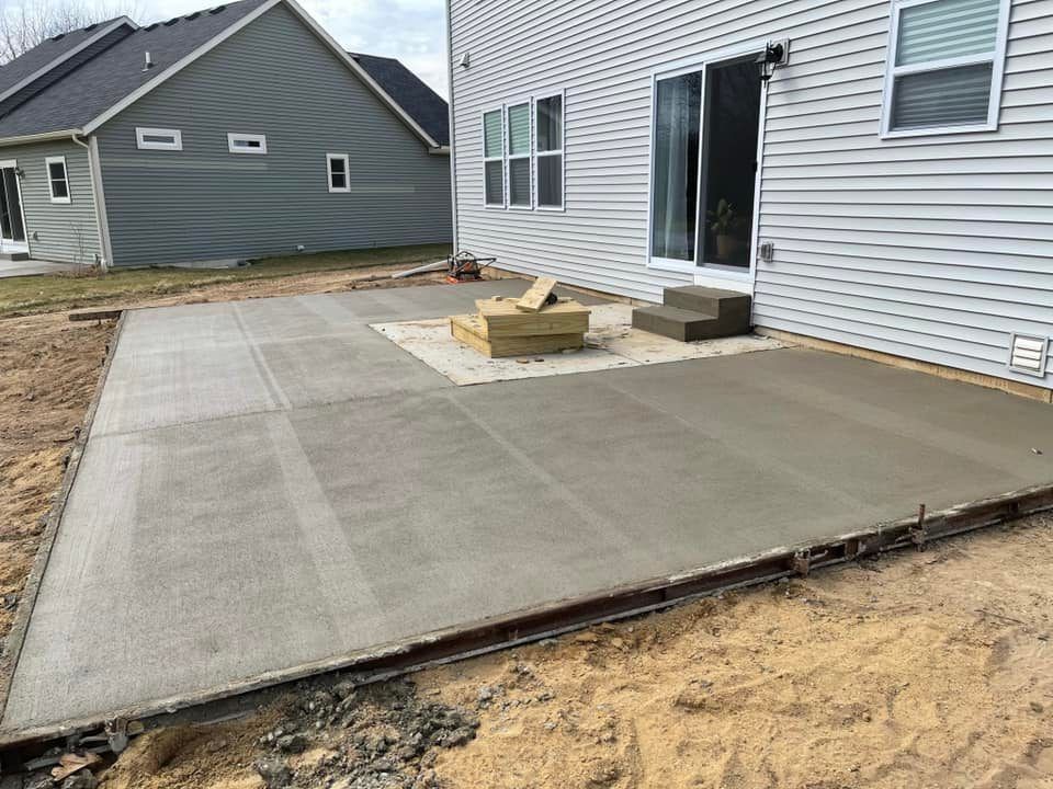 A concrete patio is being built in front of a house.