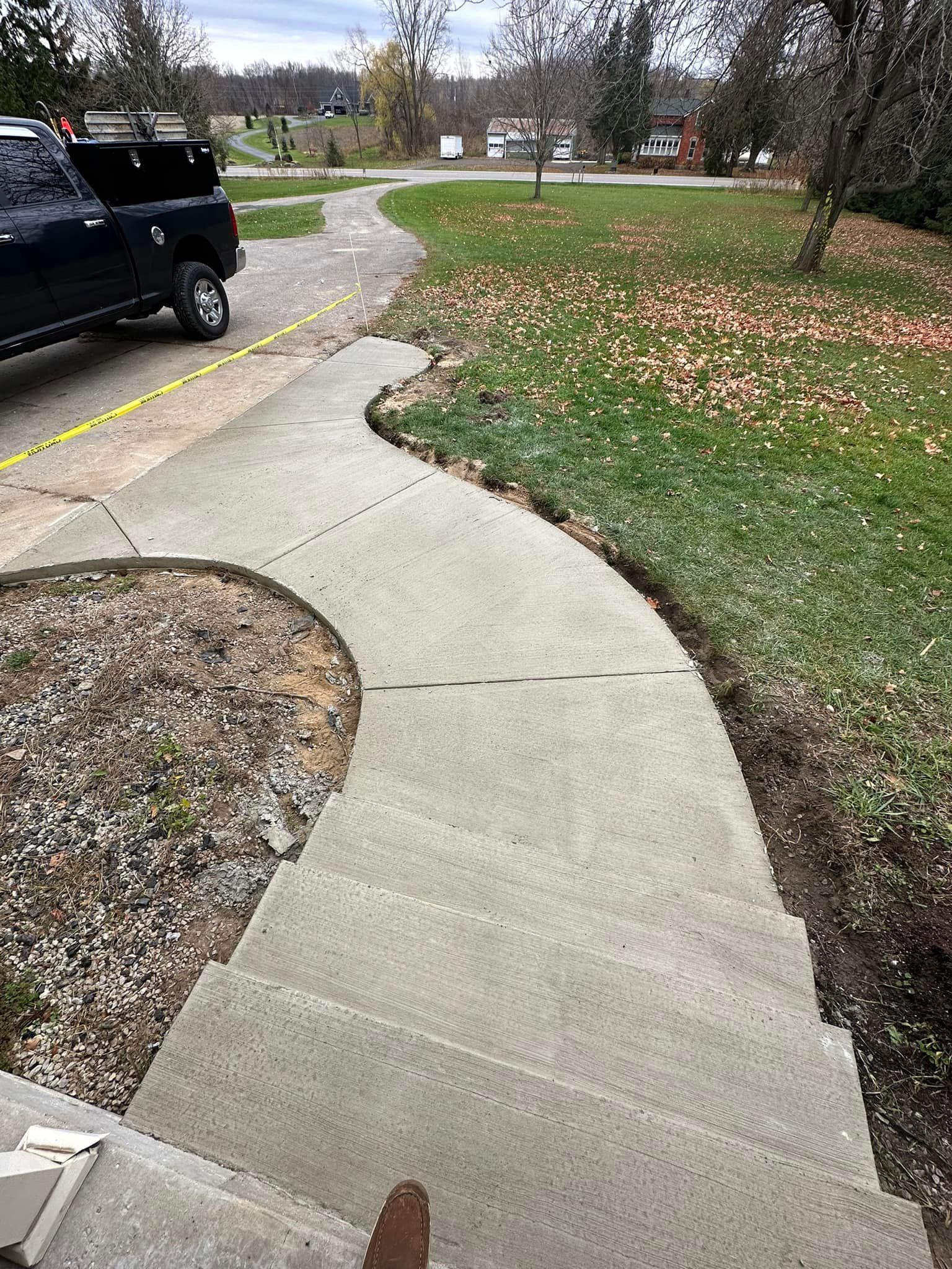 A concrete walkway with a truck parked on the side of it.