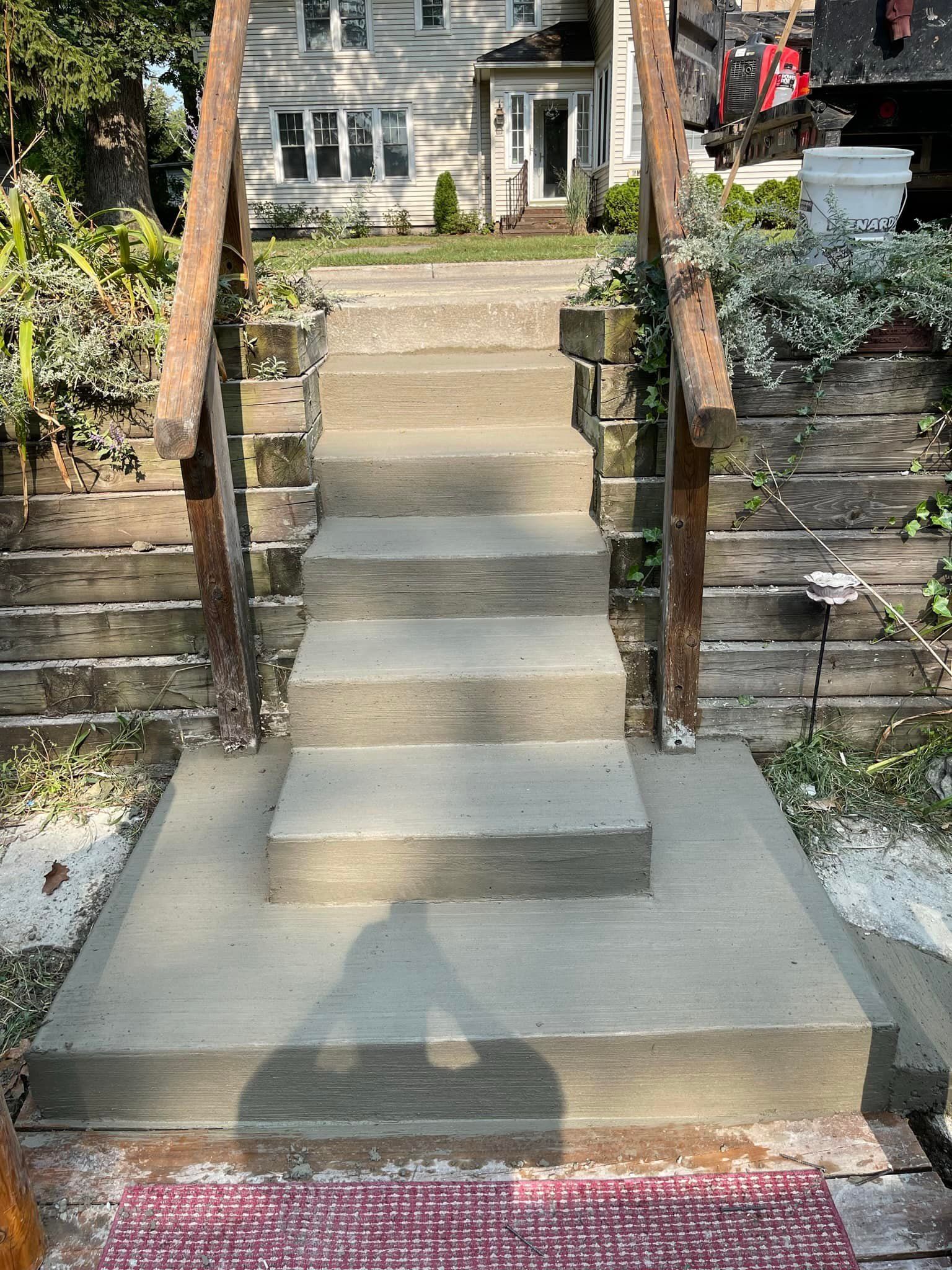 A set of stairs leading up to a house with a wooden railing.