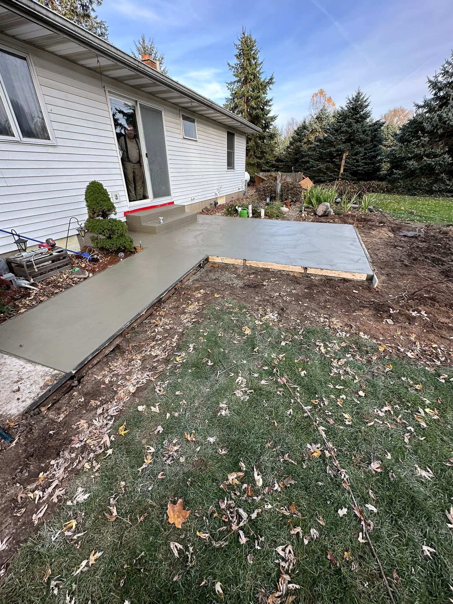 A concrete walkway is being built in front of a house.