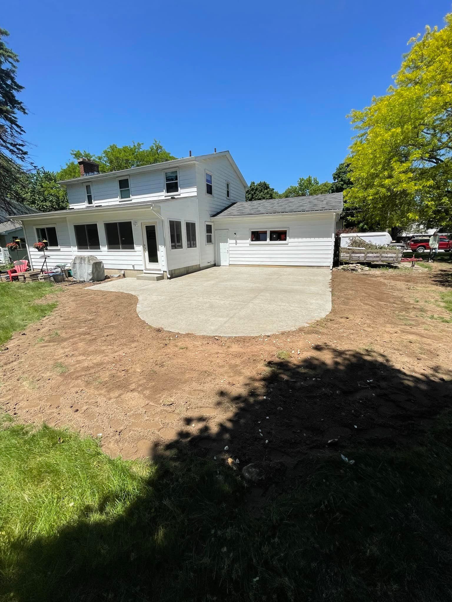A white house with a gravel driveway in front of it.