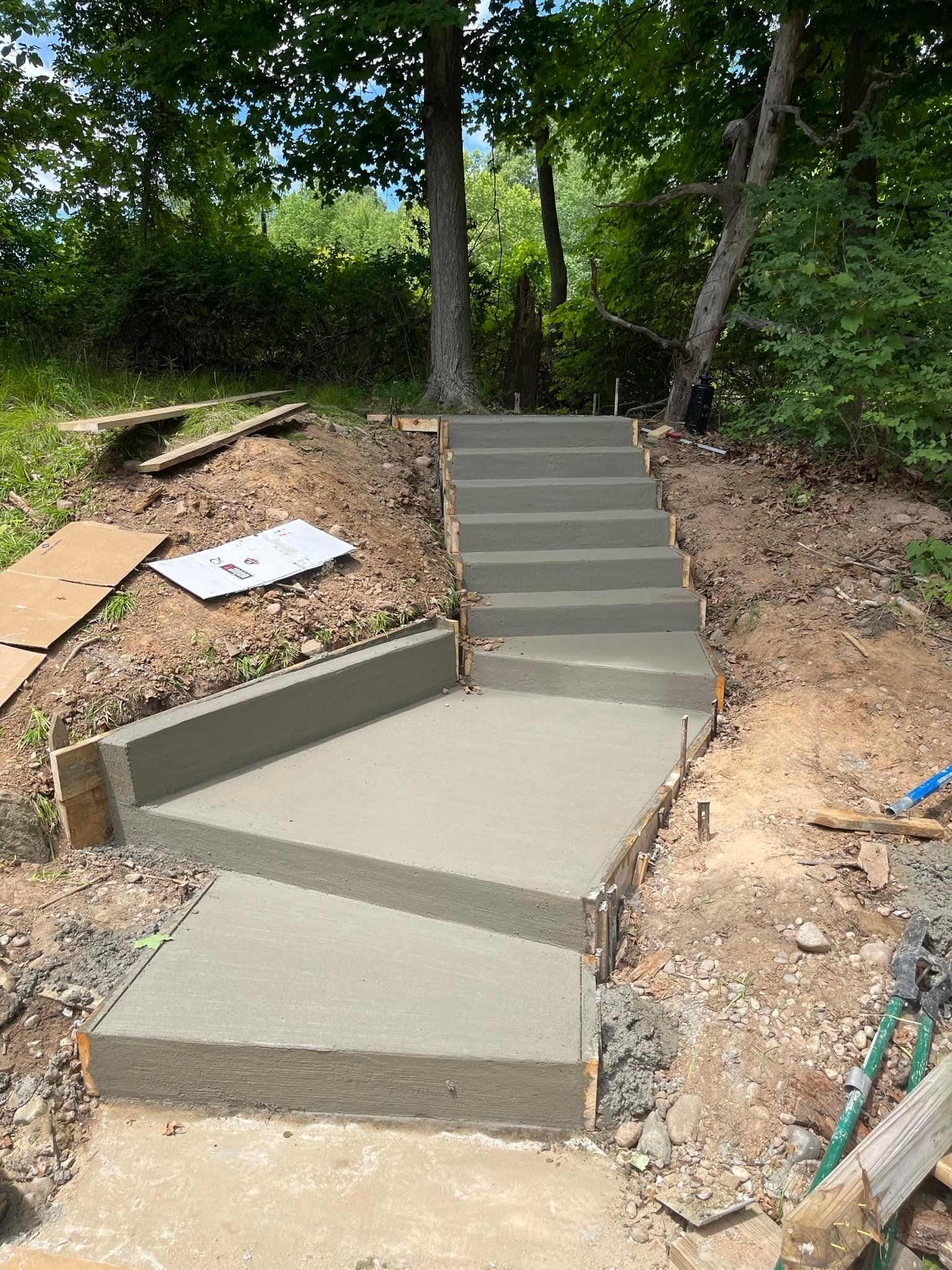 A set of concrete stairs being built on top of a dirt hill.