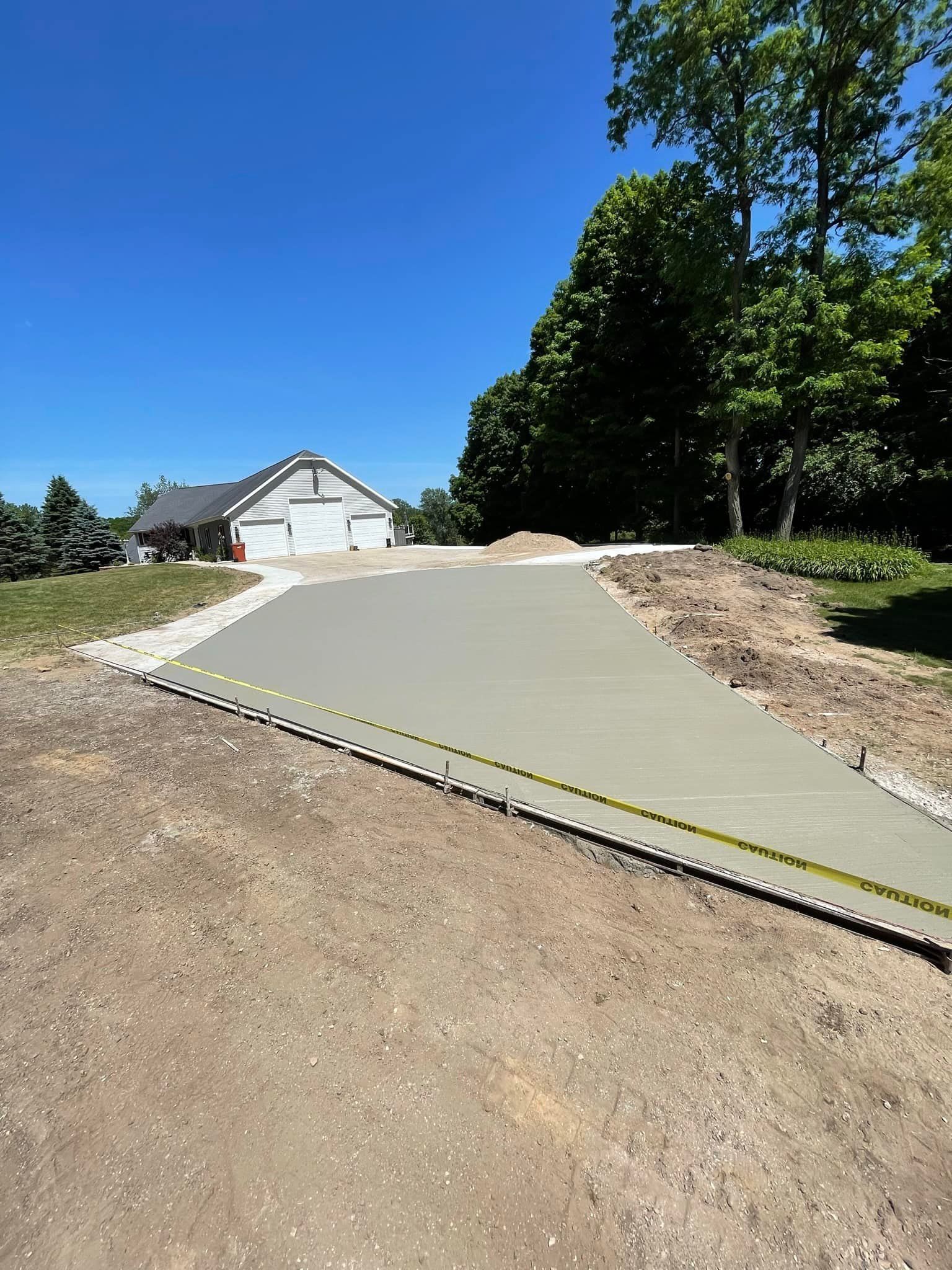 A concrete driveway is being built in front of a house.
