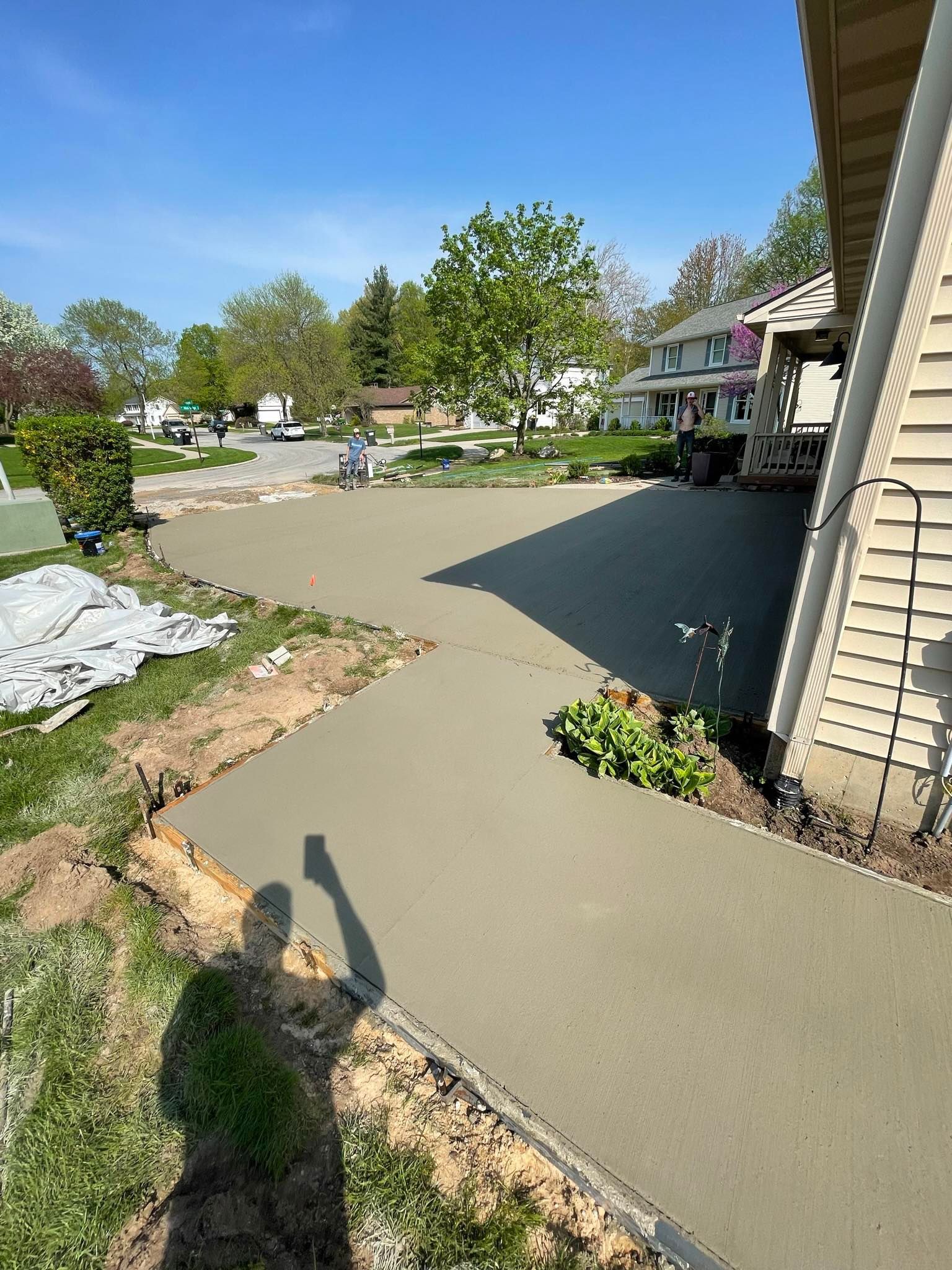 A concrete walkway is being built in front of a house.