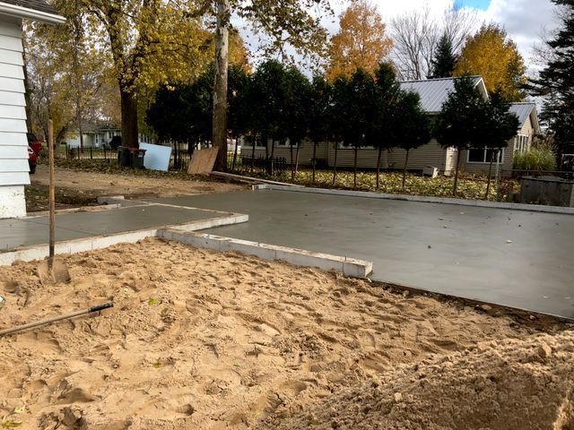 A concrete driveway is being built in front of a house.