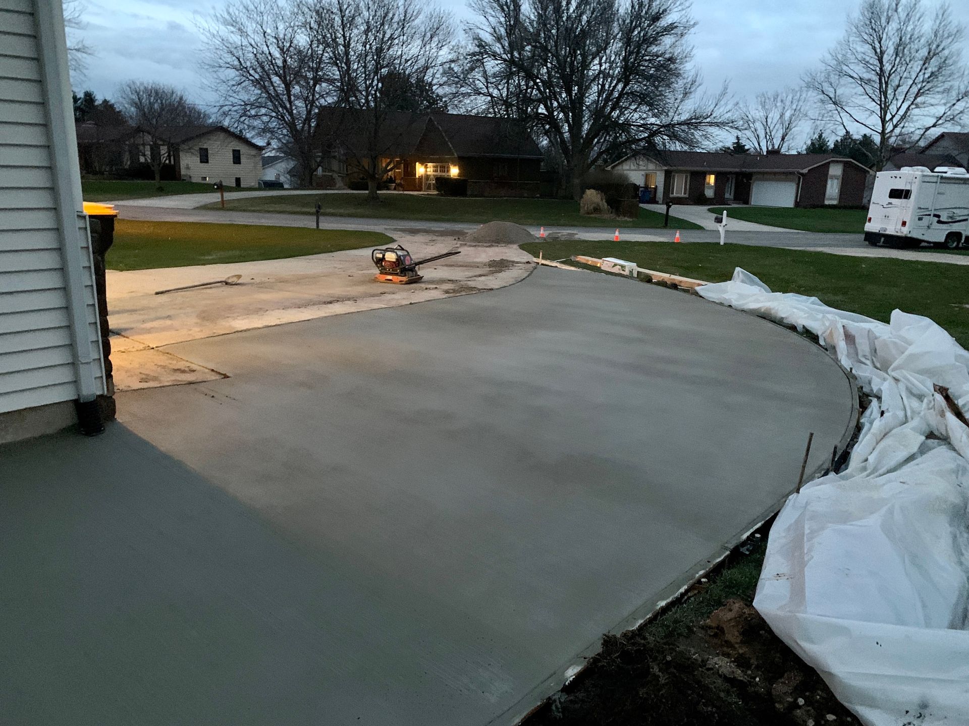 A concrete driveway is being built in front of a house.