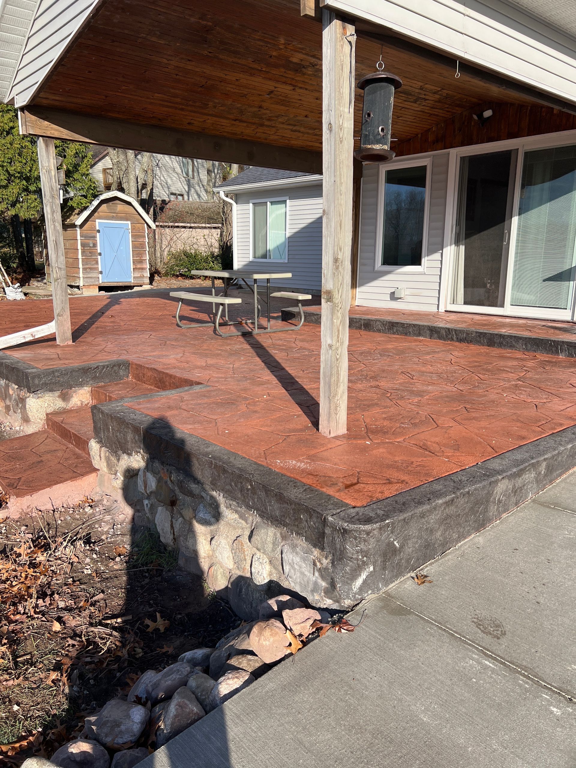 A house with a covered patio and a picnic table.