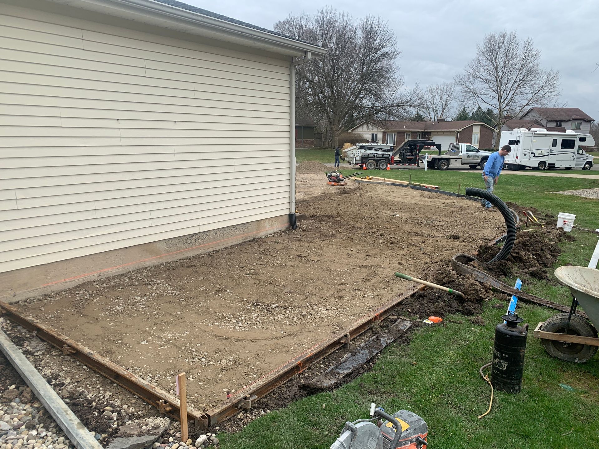 A concrete driveway is being built in front of a house.